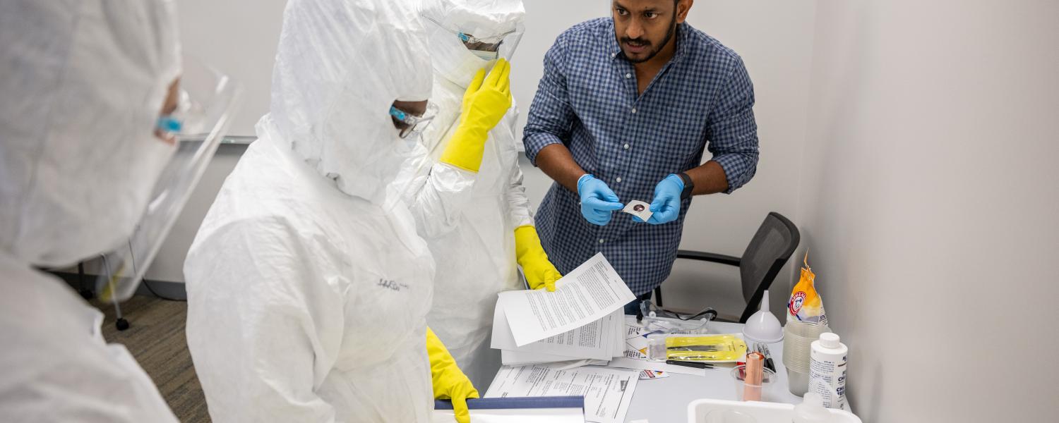 Three technicians in a cleanroom lab