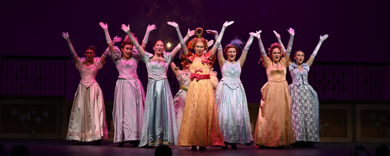 actors in colorful fantasy costumes sing and dance on stage