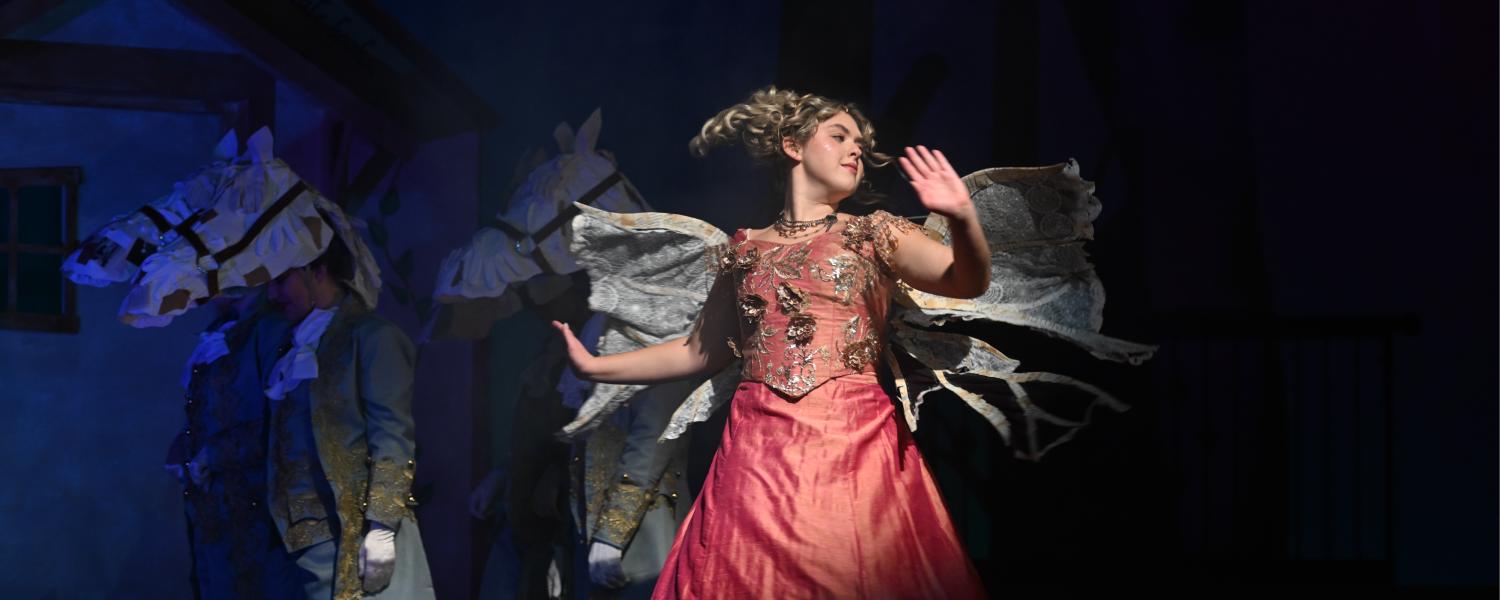 an actress twirls on stage to complete a costume transformation as a fairy godmother
