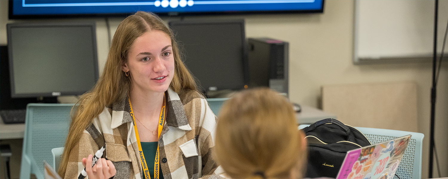An ASC tutor works with another student in the Academic Success Center.