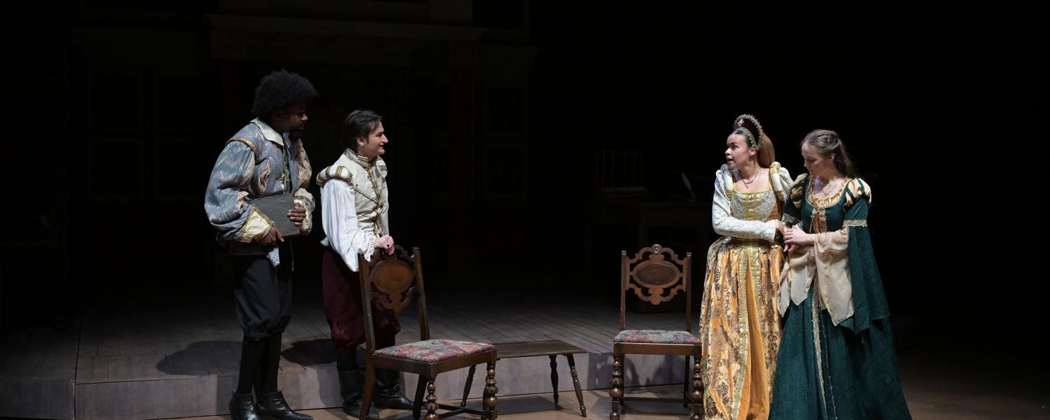 actors perform a dialogue on stage dressed in medieval costumes