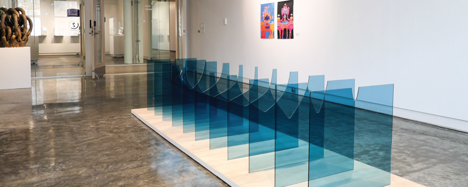 Exhibit featuring blue glassware square-like shapes descending in a line