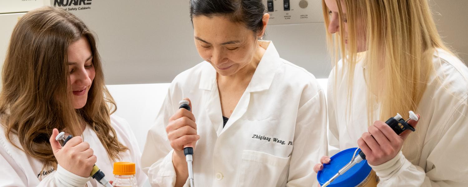 Students work with a faculty member in a biochemistry lab.