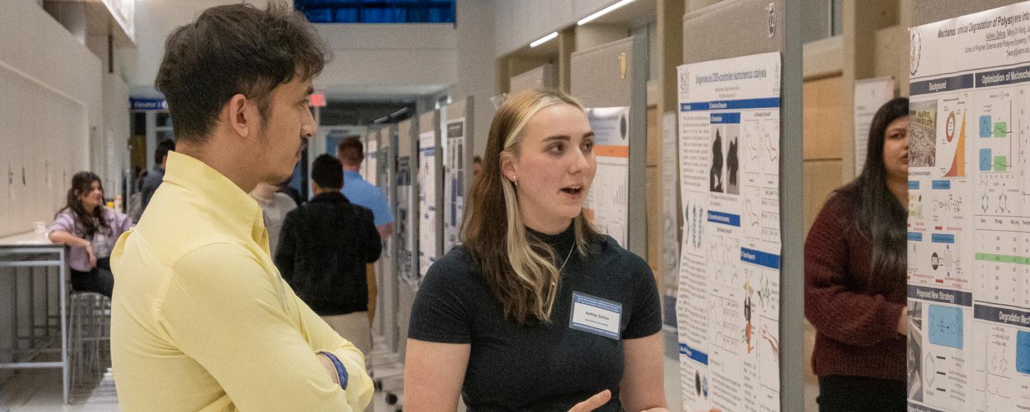 A student discusses her research at a poster session.
