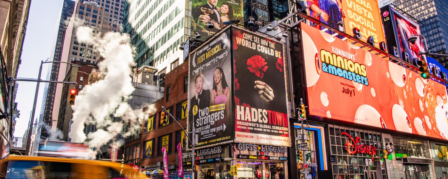 A bustling city scene with a taxi speeding by numerous billboards, digital advertisements and buildings