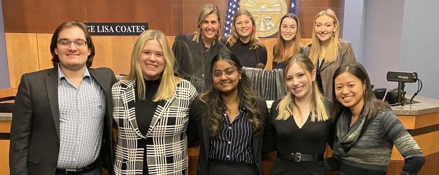 A group of students stand together, smiling and posing for a photo.