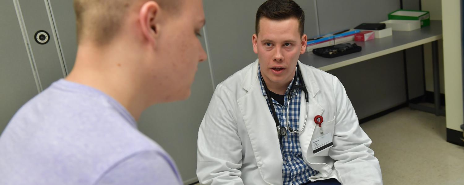 A psychiatric mental health nurse practitioner speaks with a student.