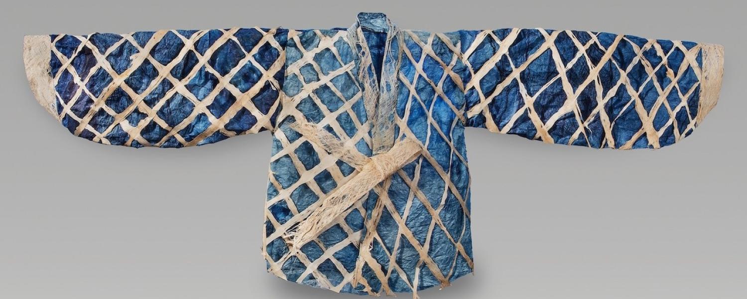 Garment laid out with arms to side; dark blue, light blue colors with a white criss cross pattern. 