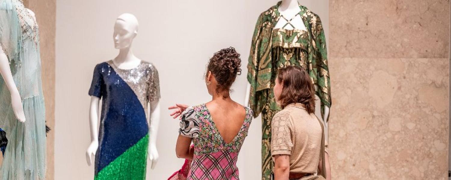 Visitors view garments from a collection donated by Aileen Mehle while on display in the museum.