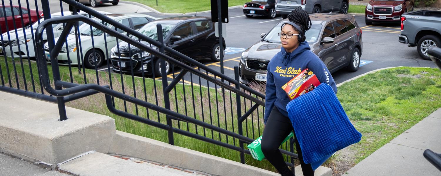 An upward bound student carrying her things up the stairs