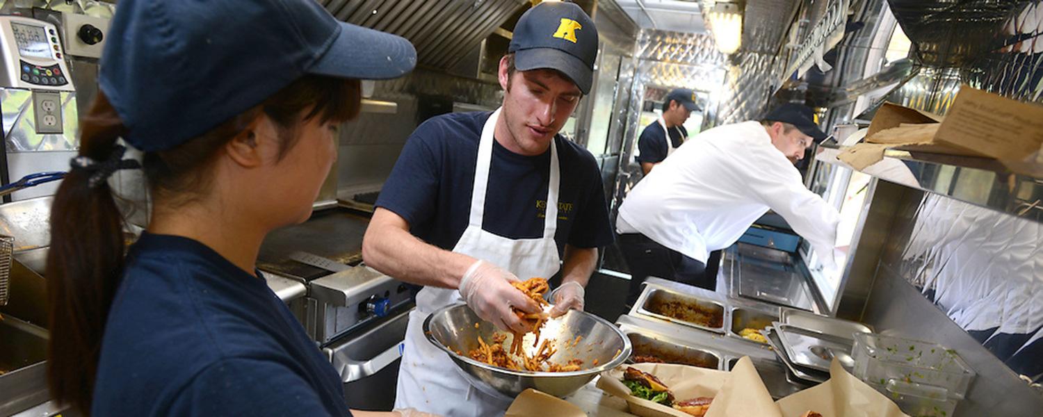Student dining services employees preparing food in a kitchen on campus