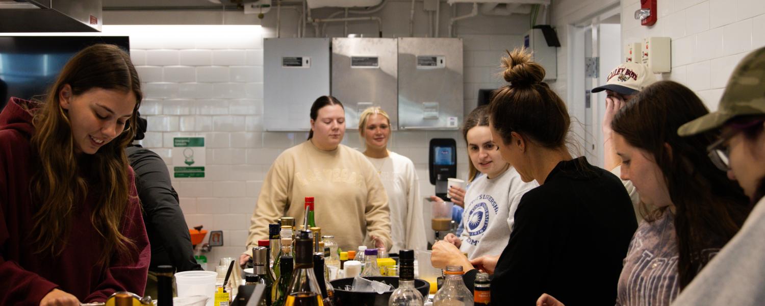 Students gathered around a counter in the Innovation Teaching Kitchen in the Design Innovation Hub.