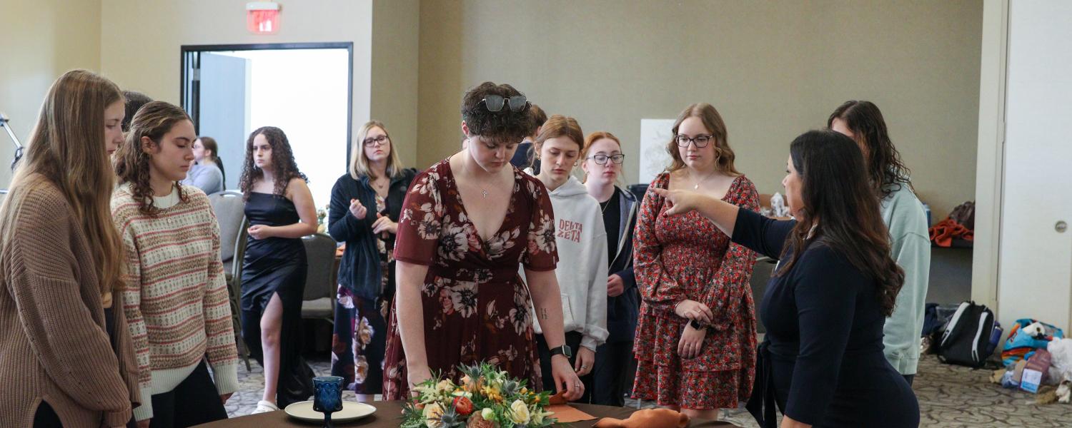 Hospitality and Event Management students preparing a table setting during a wedding styled shoot at the Kent State Hotel.