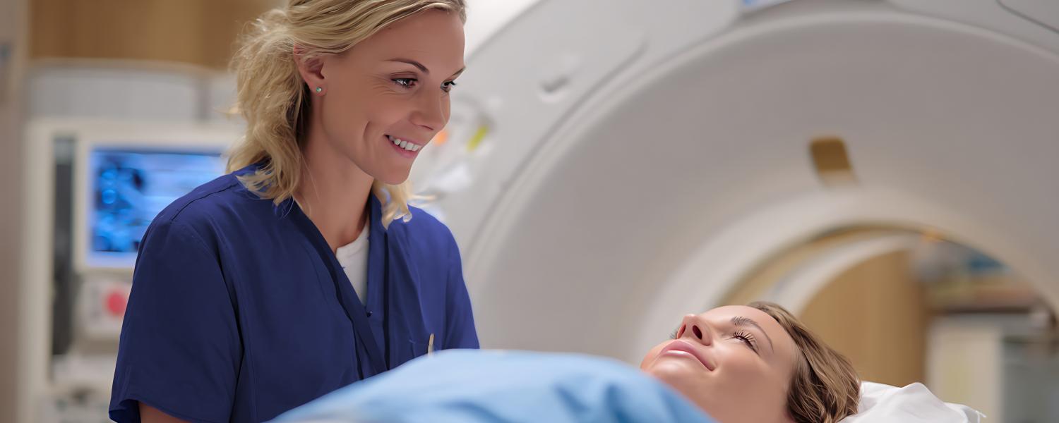 a female nurse smiles at a patient going into an mri machine