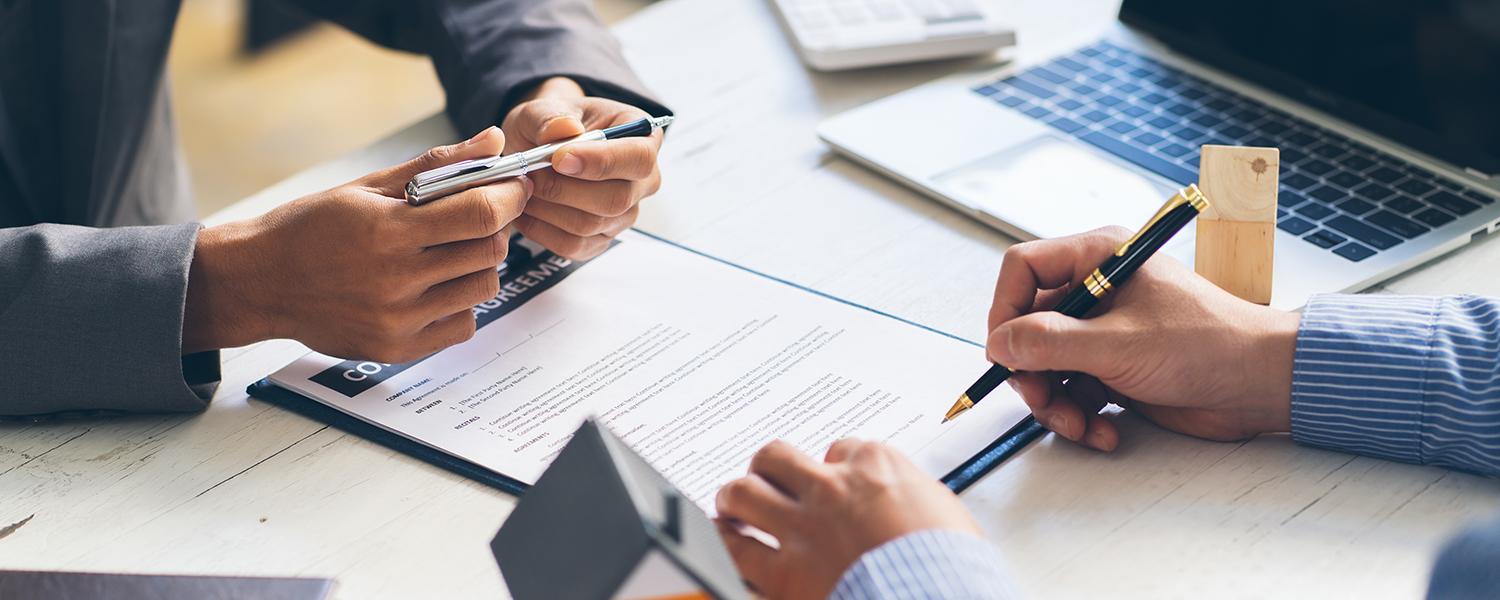 two sets of hands signing a contract