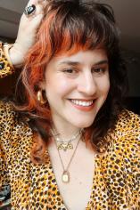 Headshot of Danielle wearing yellow patterned shirt with black and red hair