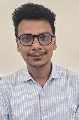 Picture of male student wearing light blue patterned shirt.