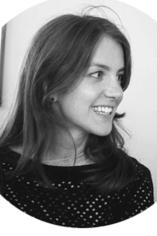 A black and white headshot of Elena, she has straight dark hair and her gaze looks at something in the distance