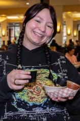 Student smiling while trying a food sample from golden habanero