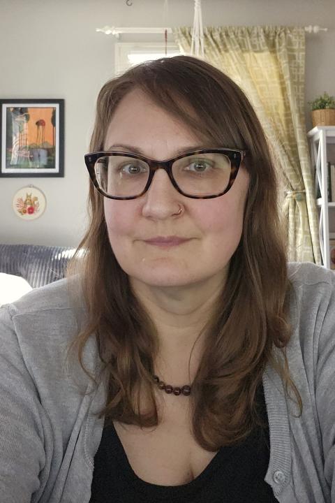 An image of a white middleaged woman with glasses and brown hair