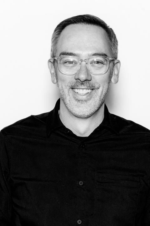 Black and white headshot of professor in sweater
