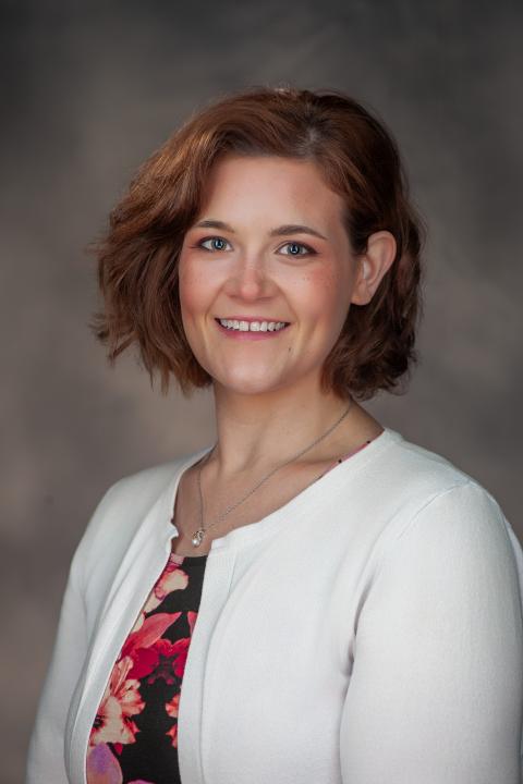 Professional headshot of Alyssa DeSimone, a smiling woman with short brown hair wearing a white cardigan