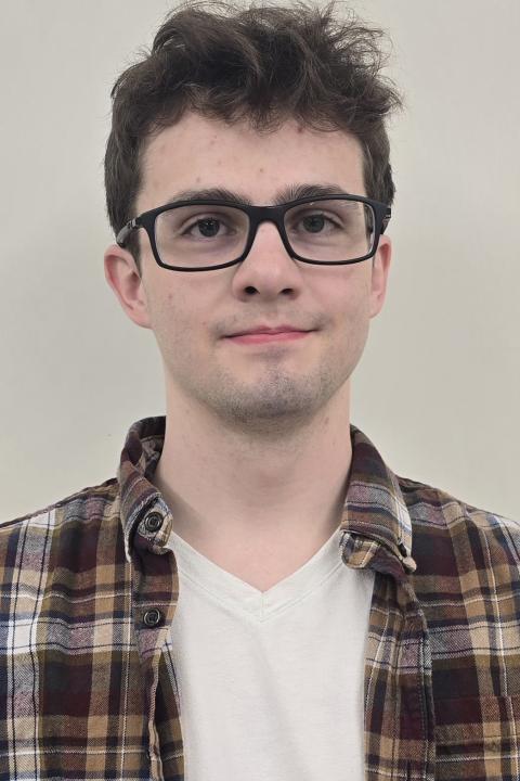 image of a male student wearing flannel and plain white inside tshirt wearing eyeglasses