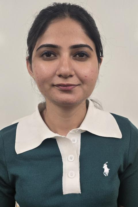 image of a female student wearing green and white casual shirt, hair in ponytail.