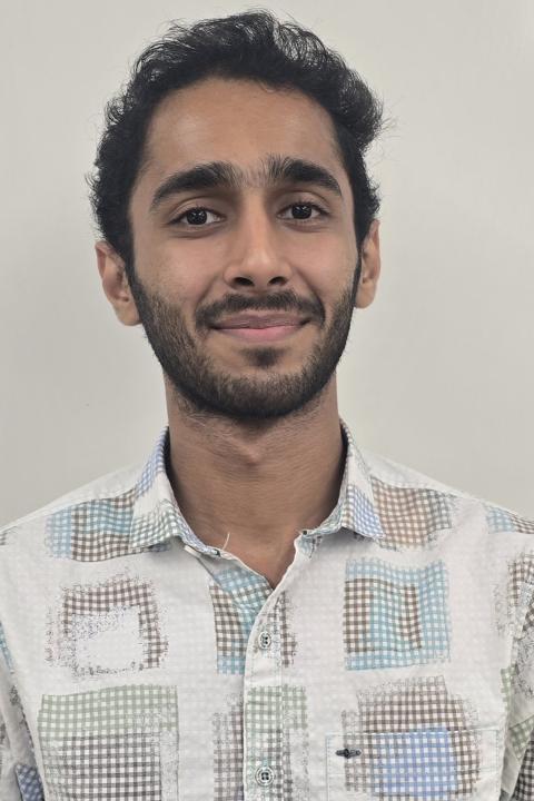 Picture of male student wearing white patterned shirt.