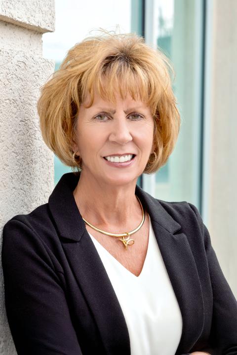 Mary Helen Smith smiles in a professional portrait while wearing a black blazer and white blouse.