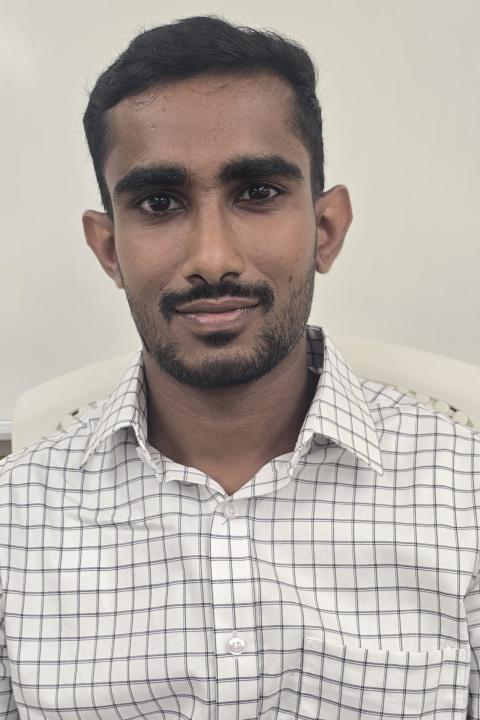 image of a male student wearing a patterned white buttoned shirt
