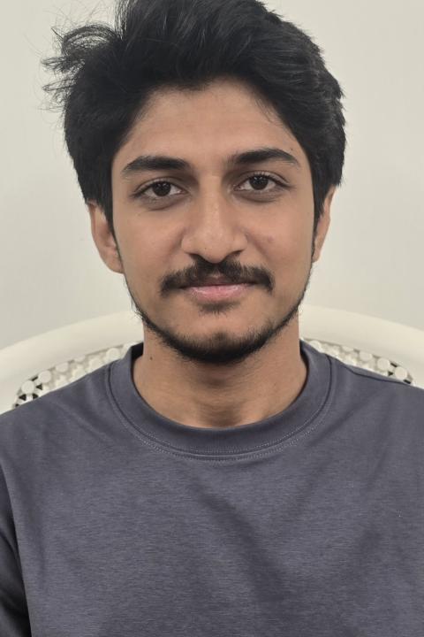 image of a male student wearing a plain grayish tshirt.