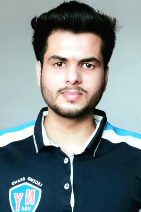 Picture of male student wearing dark blue t-shirt.