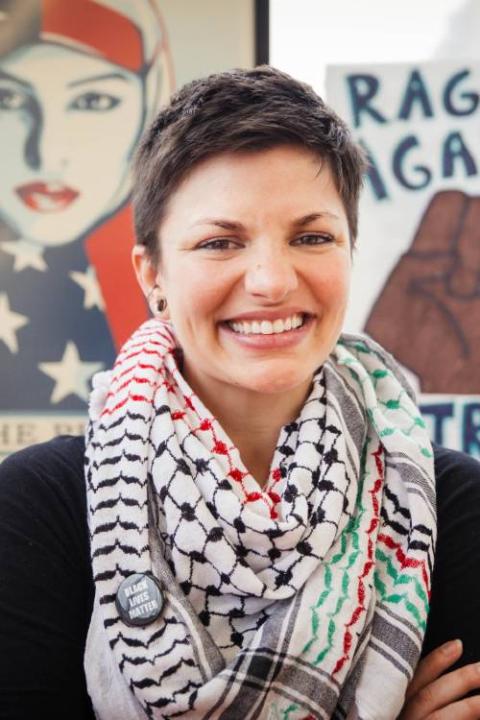 Smiling individual with short dark hair