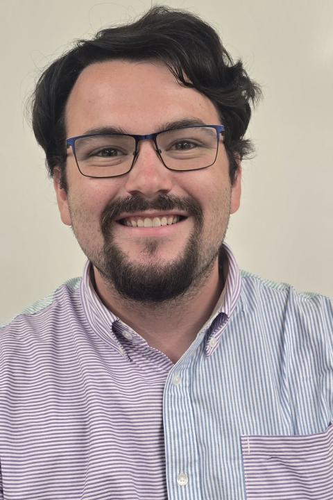 Picture of male student wearing purple/bluish shirt.