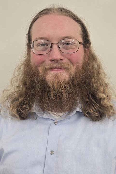 picture of a male student wearing light blue buttoned shirt
