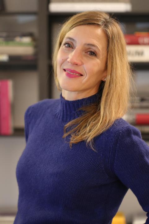 Headshot of Alessandra smiling at camera, her long hair is straight and blonde