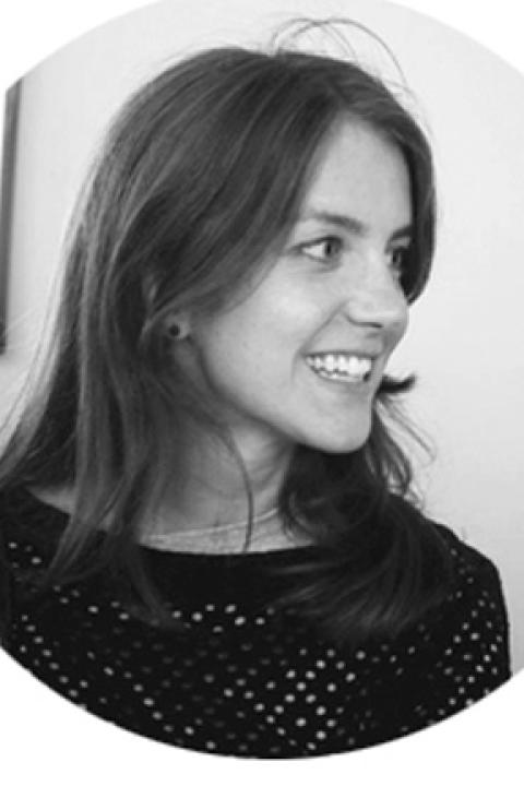 A black and white headshot of Elena, she has straight dark hair and her gaze looks at something in the distance