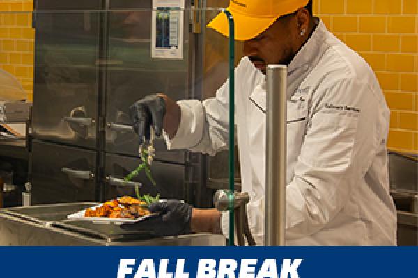 A culinary employee serving up a dish of food.