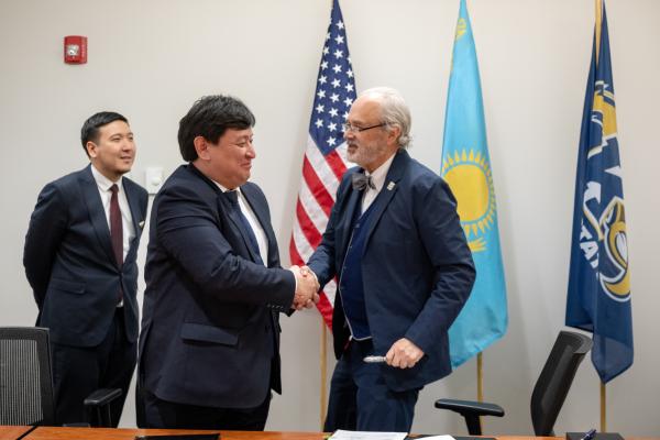 President Todd Diacon shakes hands with Kairat Zhakupov, acting chairman of the board and president of the Civil Aviation Academy, after signing an agreement for an aeronautics collaboration.