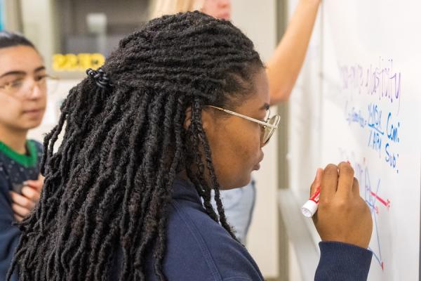 Students writing on a white board
