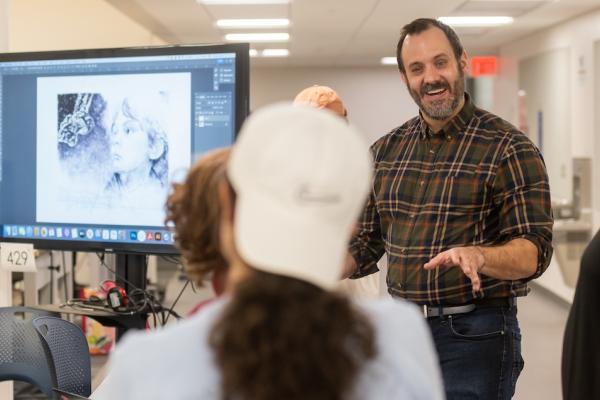 Chad Lewis Teaching next to a monitor