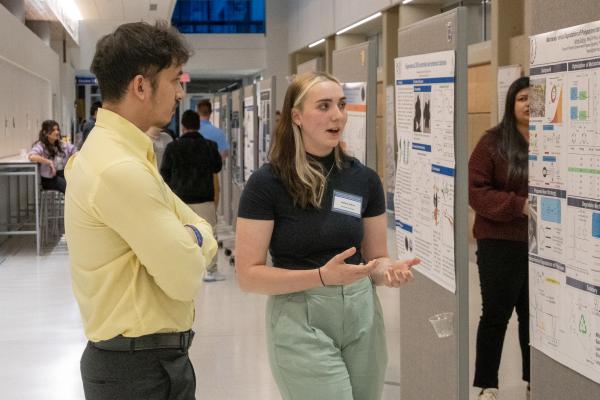 A student discusses her research at a poster session.