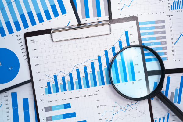 A magnifying glass hovering over a paper with a graph on it.