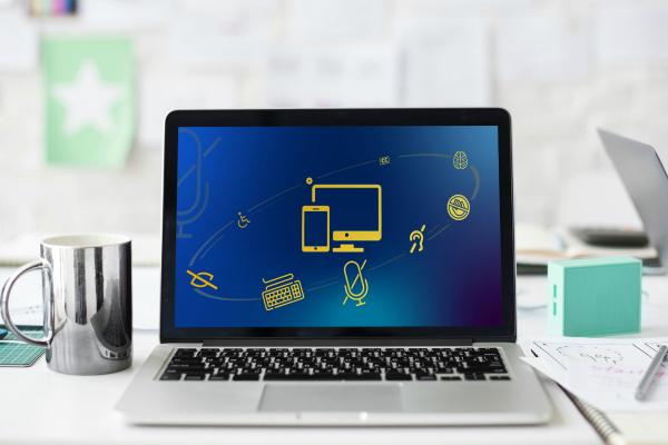 Computer on desk with coffee mug and notebooks