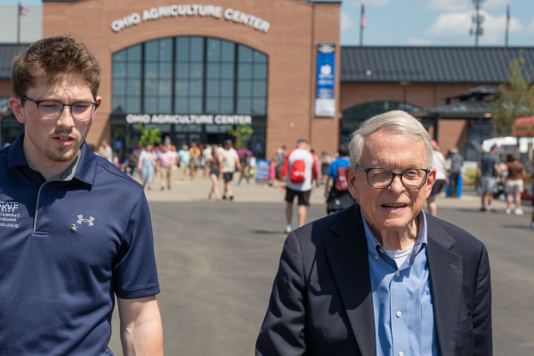Kent State student Nathan Smith (center) walks with Ohio first lady Fran DeWine (left) and Ohio Gov. Mike DeWine (right) at the Ohio State Fair.
