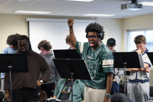 A class of musical theatre students sing along to scores of music