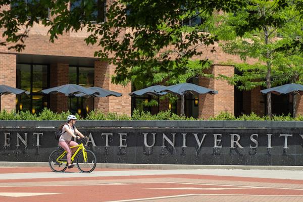 Kent State student rides bike in front of fountain on Risman Plaza - photo credit Bob Christy - WEB.jpg