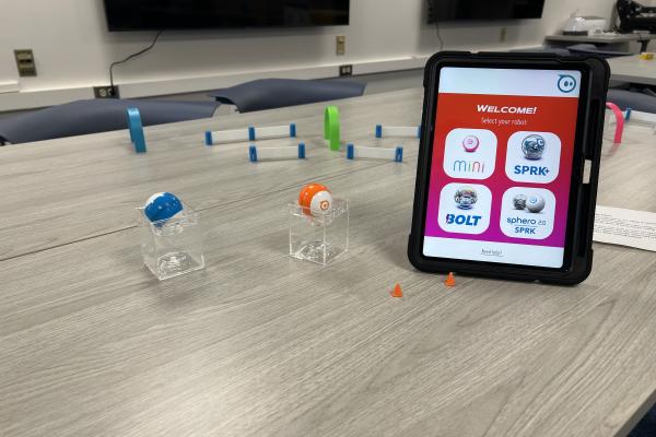 An image of the Sphero Minis and the iPad used to control them, with a Sphero race course in the background