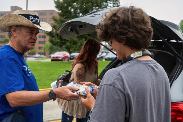 Kent State President Todd Diacon hands a pair of Kent State-branded socks to a student during Move-In.